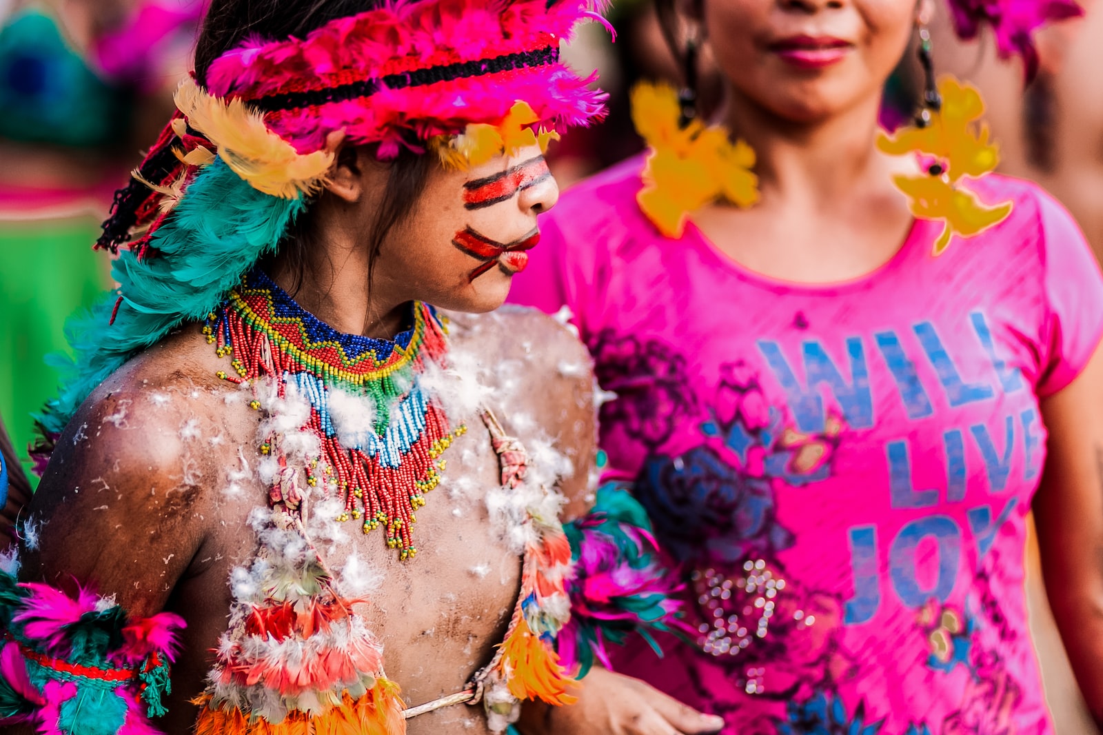 Photo par Junior REIS woman in pink crew neck shirt with multicolored feather headdress