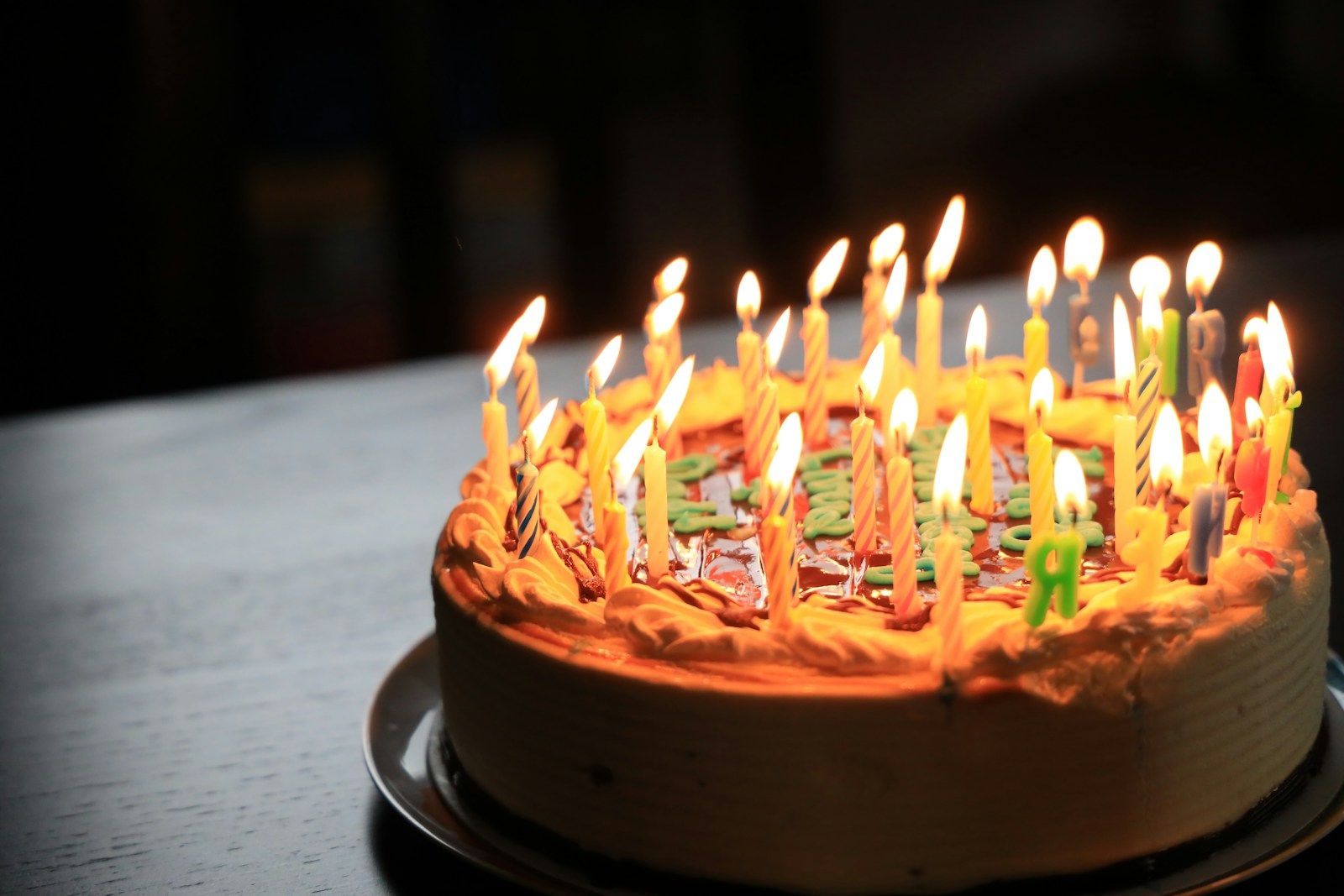 Photo by Richard Burlton lighted candles on brown cake