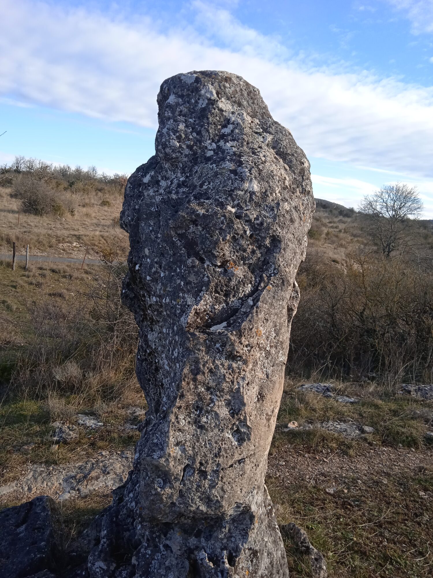 a group of people standing on top of a beach under a cloudy blue sky
