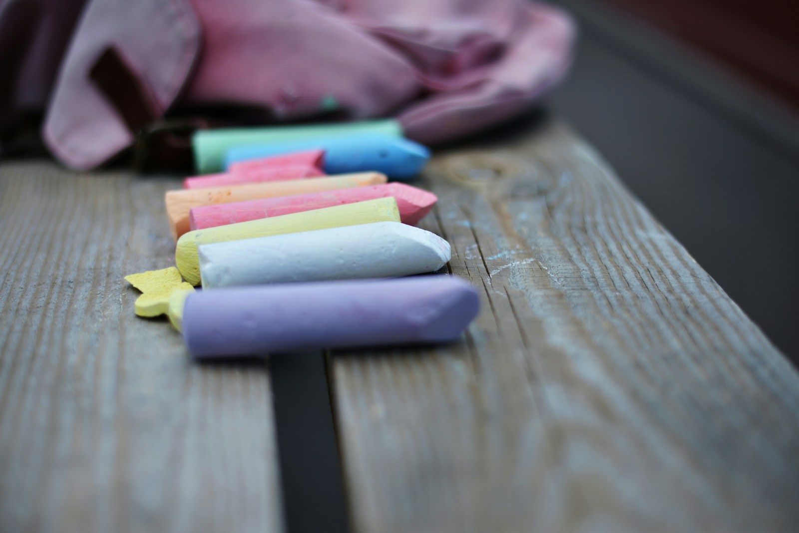a row of colored crayons sitting on a wooden table