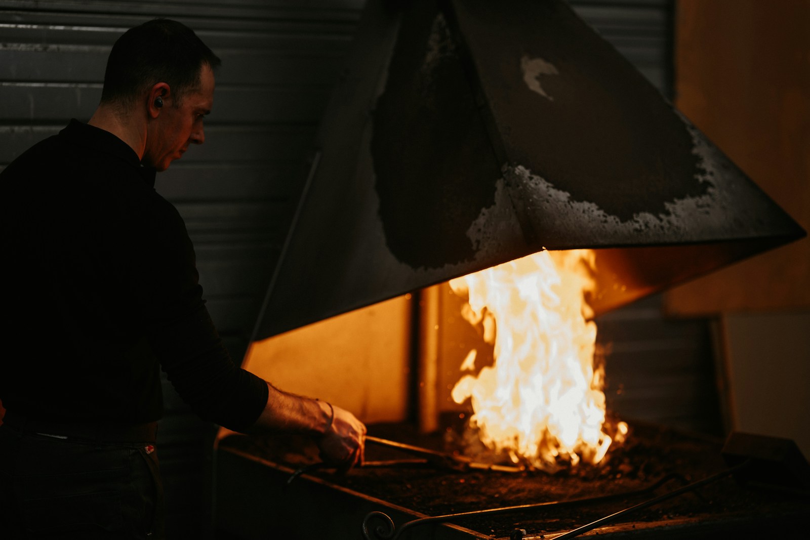 a man standing in front of a fire with an umbrella
