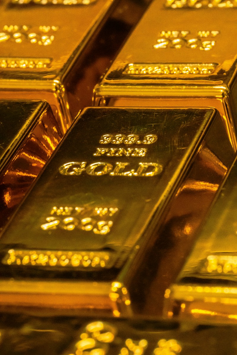 Shiny gold bars with stamped text stacked in a close arrangement